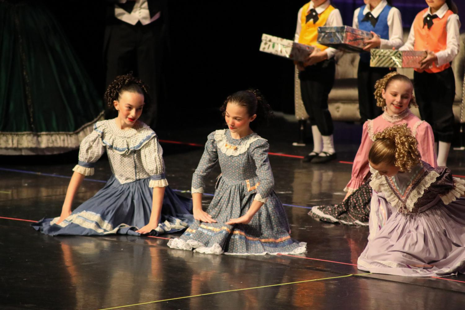 Dancers sit on the floor in party scene