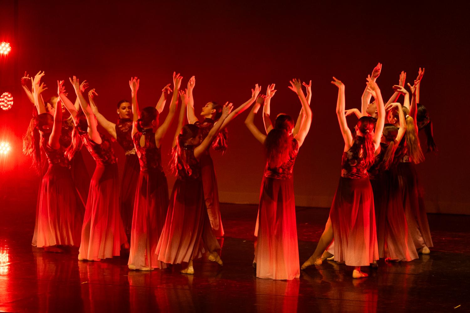 Dancers in a circle with red lighting